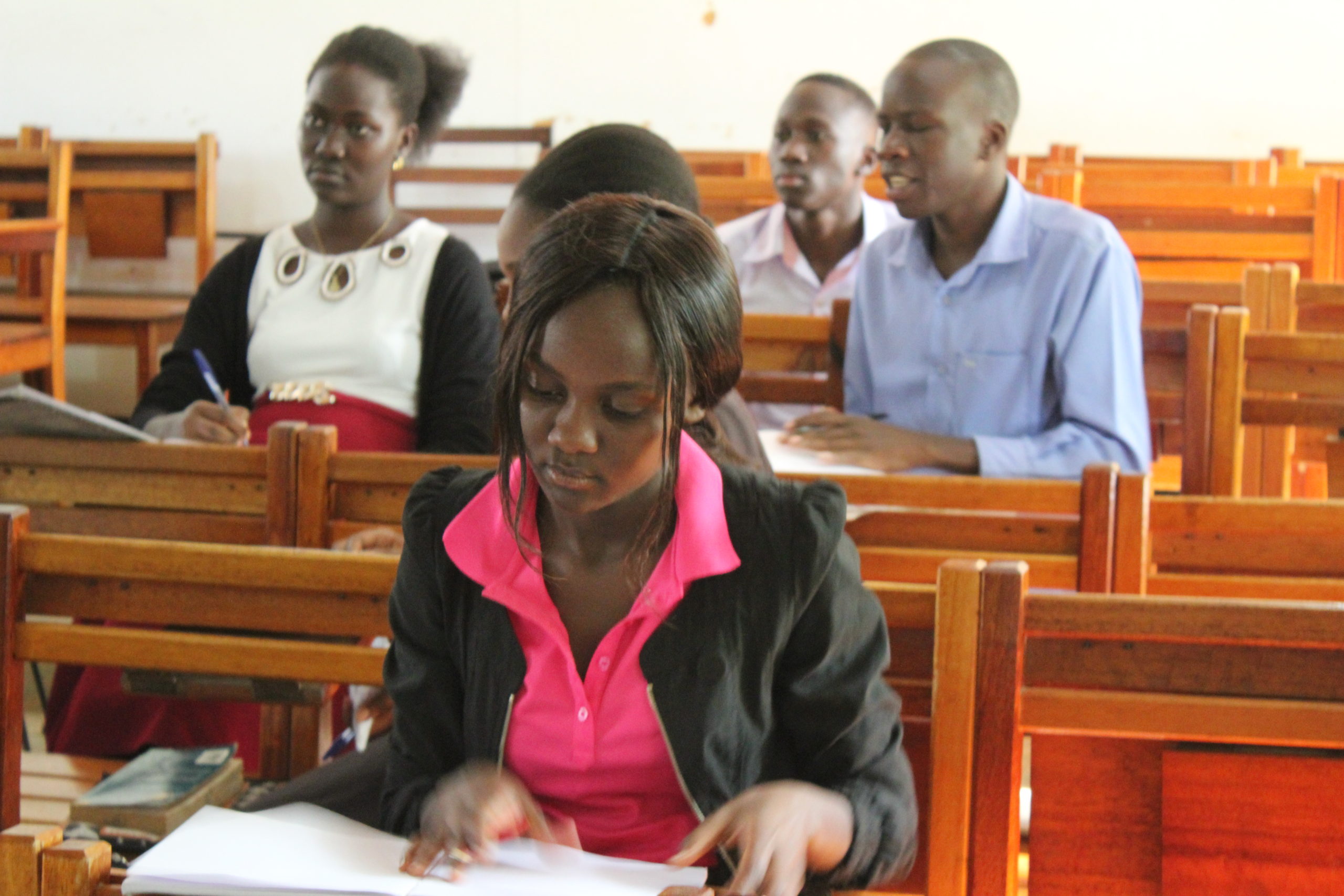 Students at Uganda Martyrs University, young woman in foreground, two young men and one young woman in backhground