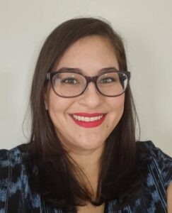 A Mexican woman with glasses smiling into the camera
