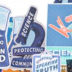 A number of posters held up at a protest march advocating for science for the common good