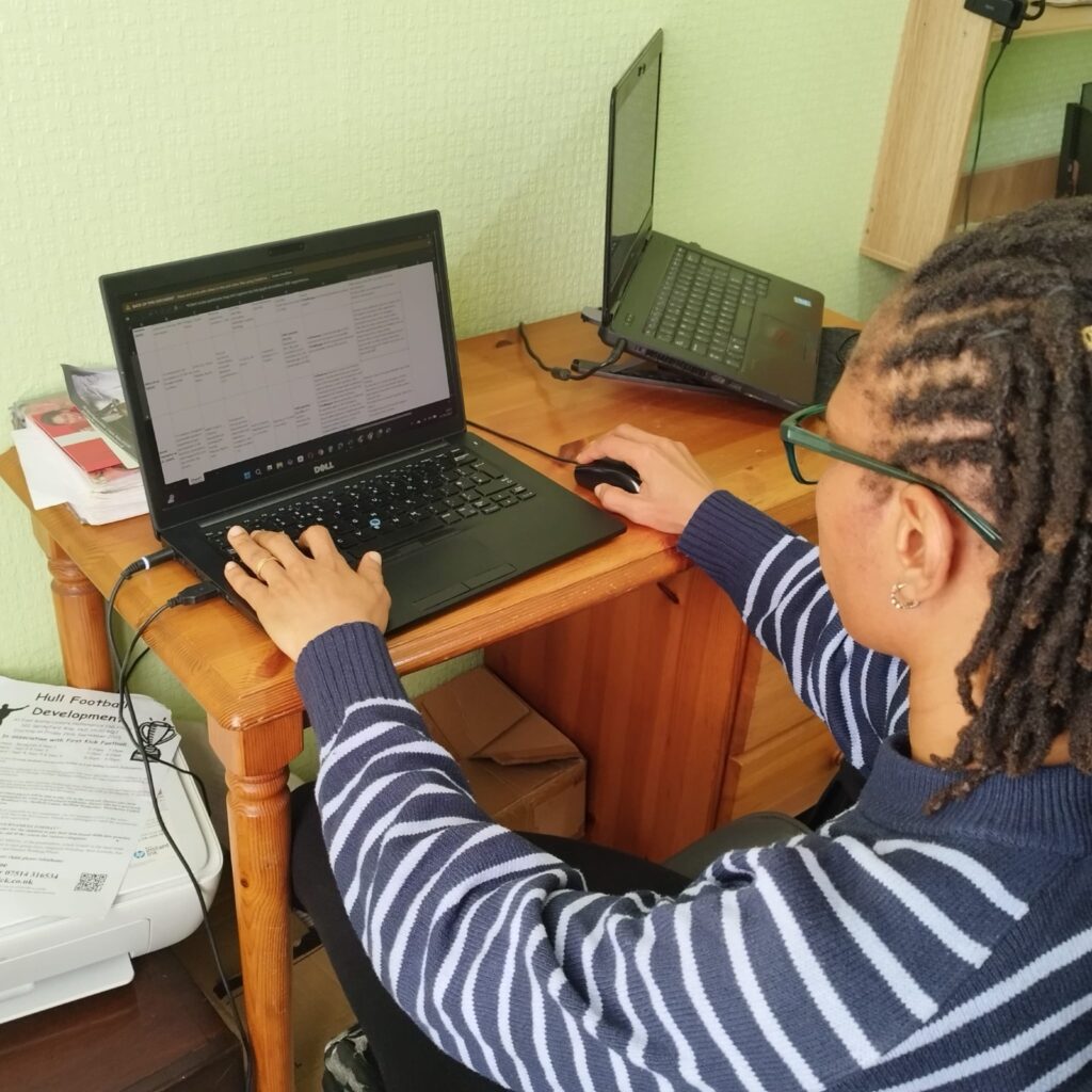 Ugo working at her desk on a laptop.