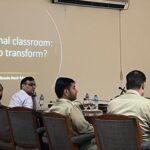Nasir Mansoor facilitating a workshop in a room with several people, both men and women