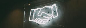 A neon sign of two shaking hands